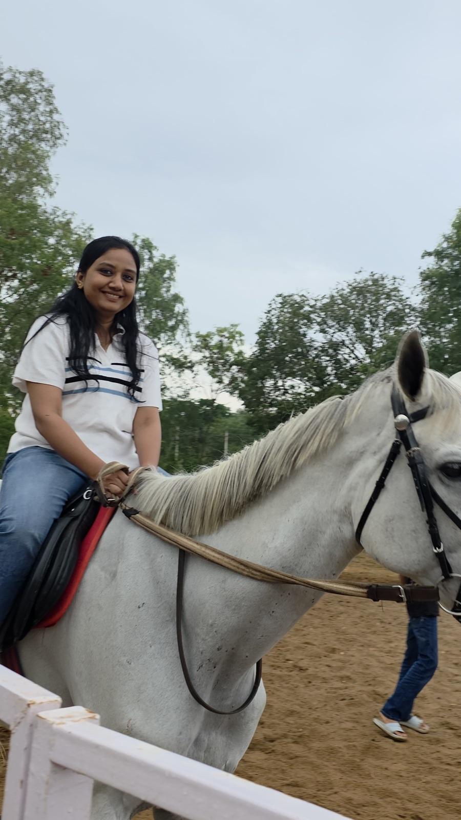 Guest smiling on horseback at the stables